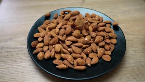 Plate of almonds on a wooden table Stock Footage 320726720