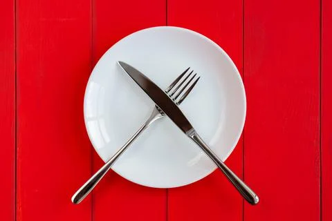 Plate and cutlery on the table. Fork and knife on an empty plate. A sign that Stock Photos