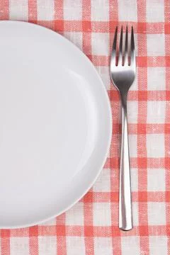 Plate and fork over checkered background Stock Photos