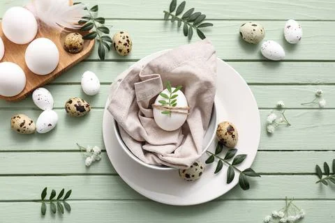 Plate and holder with Easter eggs on green wooden background Stock Photos