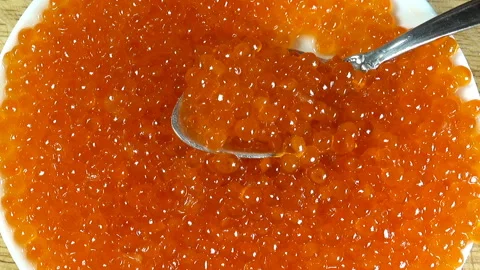 A plate and spoon full of red caviar. Stock Footage 133344616