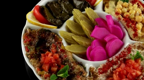 Plate of assorted Arabic appetizer with pickled cucumbers and turnips, loop Stock Footage 61706963