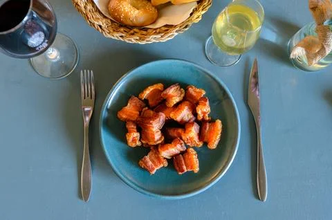 A plate of bacon is on a table with a fork and knife Stock Photos