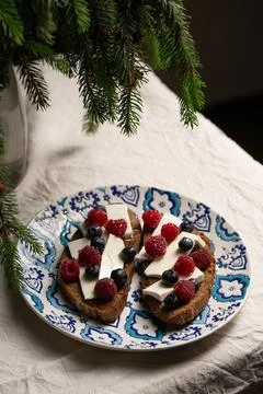 A plate of bread with blue and white designs and blueberries Stock Photos