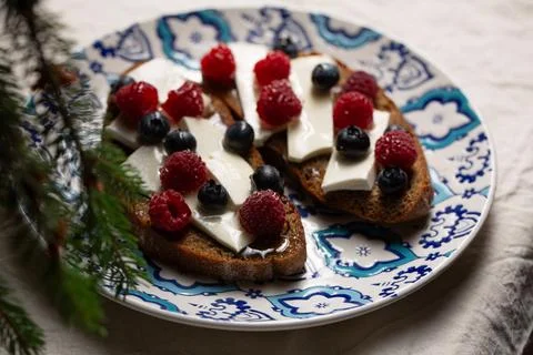 A plate of bread with blue and white designs and blueberries Foto stock