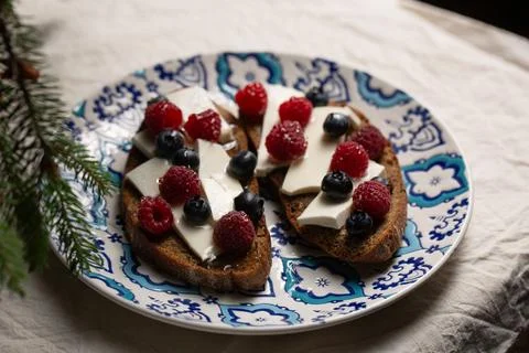 A plate of bread with blue and white designs and blueberries Foto stock