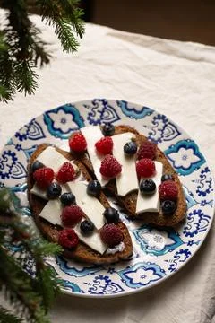 A plate of bread with blue and white designs and blueberries Stock Photos