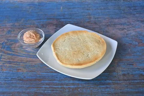 A plate of bread with a jar of spread on a table Foto stock