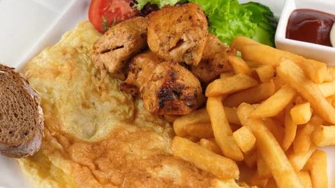 Plate of breakfast, Omelette with chicken kebab, french fries and vegetables Stock Footage 78358697
