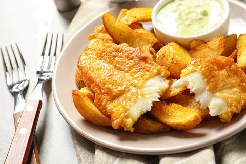 Plate with British Traditional Fish and potato chips on grey background, clos Stock Photos