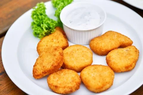 A plate of chicken nuggets on a table Stock Photos