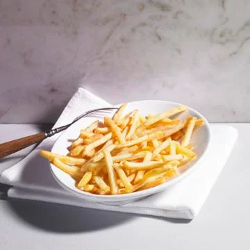 A plate of chips with a fork Stock Photos