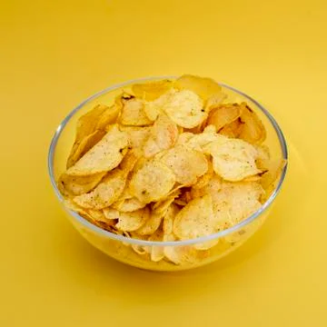 A plate of chips on a yellow background closeup Stock Photos