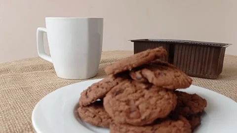 A plate of chocolate biscuits and a cup of hot tea for the snack Stock Footage 150398860