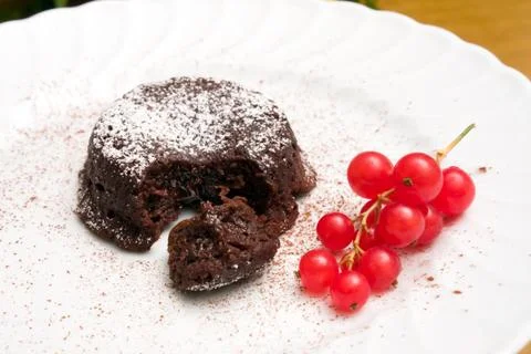 Plate with chocolate cake and redcurrant Фото