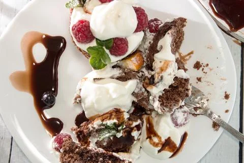 Plate with chocolate cake decorated with raspberry, wipped cream and mint. Foto stock