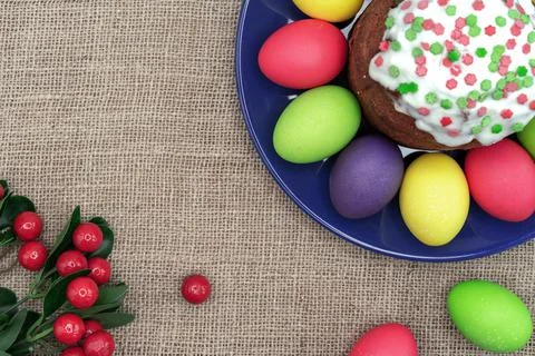 Plate with colorful Easter eggs, Easter cake and red berries. Stock Photos
