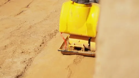 Plate compactor machine compacting sand ground Stock Footage 341294865