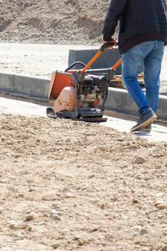Plate compactor for for soil compaction pavement or sidewalk in the city. Wor Stock Photos