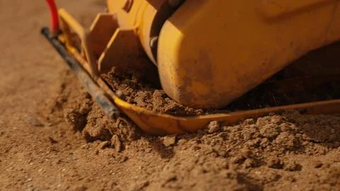 Plate compactor vibrating soil for ground preparation Stock Photos
