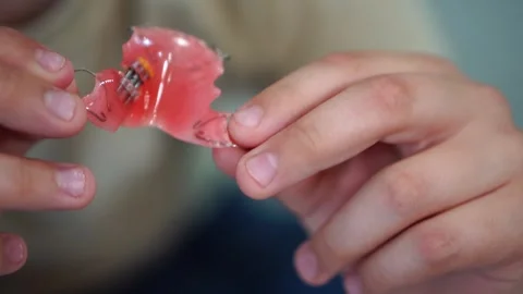 A plate for correcting the bite in children in the hands of a child close-up 库存影片 307288906