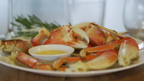 Plate of crab legs served on plate with butter and garnish. Stock Footage