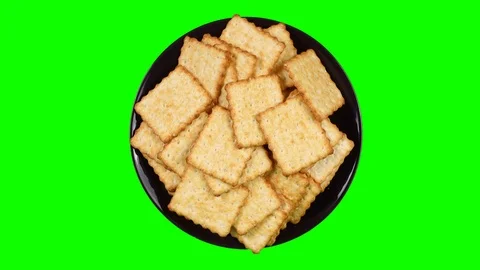 A plate with crackers rotates on a green background. Stock Footage 93434077