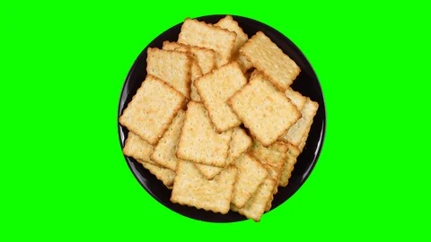 A plate with crackers rotates on a green background. Video stock 95115468