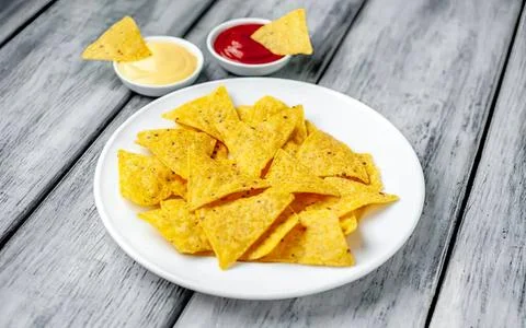 Plate of crispy tortilla chips with salsa and cheese dip Stock Photos
