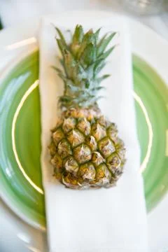 Plate decorated with a pineapple and decor, green and white colour Fotos Stock