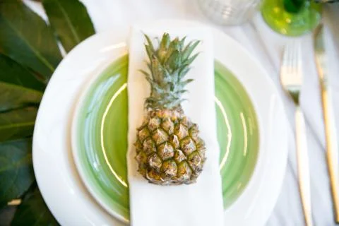 Plate decorated with a pineapple and decor, green and white colour Fotos Stock
