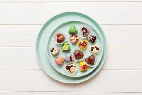 Plate with different chocolate on colored background. Assortment of fine choc Stock Photos
