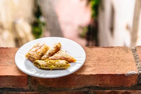 Plate with different sweets are on edge of brick fence Stock Photos