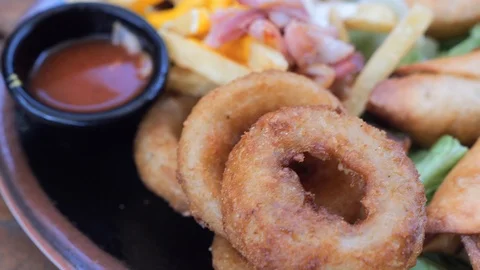 Plate with different types of hot snacks at the fresh air restaurant terrace Stock Footage 92304943