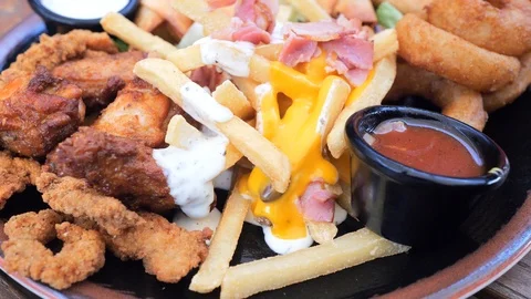 Plate with different types of hot snacks at the fresh air restaurant terrace Stock Footage 92305100