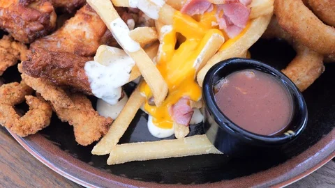 Plate with different types of hot snacks at the fresh air restaurant terrace Stock Footage 92305343