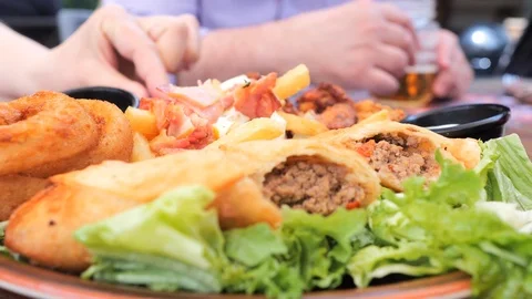 Plate with different types of hot snacks at the fresh air restaurant terrace Stock Footage 92305450