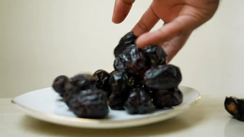 Plate of dried dates on a light-colored surface Stock Footage 318578663