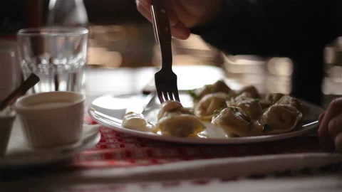 A plate of dumplings, Hands, A Fork, a Knife. Close-up Stock Footage 150274673