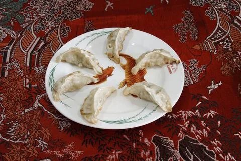 A plate of dumplings with a red background Stock Photos