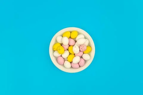 Plate with Easter eggs on a blue background, top view. Stock Photos