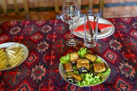 Plate of eggplant rolls on patterned table ready for serving Stock Photos