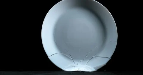 Plate falling and exploding on Black Background Stock Photos