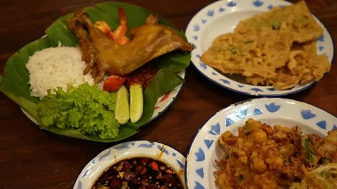 A plate of fried chicken, rice, fried fritters and vegetables Stock Footage 310815313