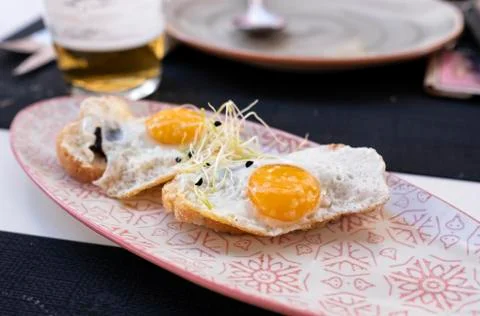Plate of fried eggs on mini crispy toast with truffle Foto stock