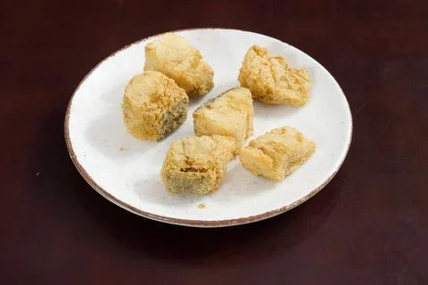 A plate of fried fish with a brown table underneath Stock-Fotos