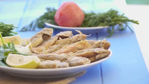 Plate of fried small fish red mullet with arugula and lemon, close up view. Stock Footage 80305172