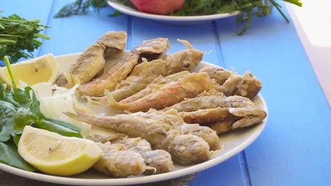 Plate of fried small fish red mullet with arugula and lemon, close up view. Stock Footage 80306305