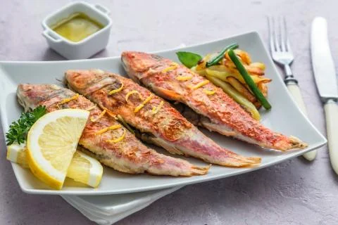 Plate of fried small fish red mullet and lemon, close view Stock Photos