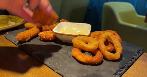 A plate of fried snacks for beer, one snack is dipped in sauce in a cafe Stock Footage 186586103